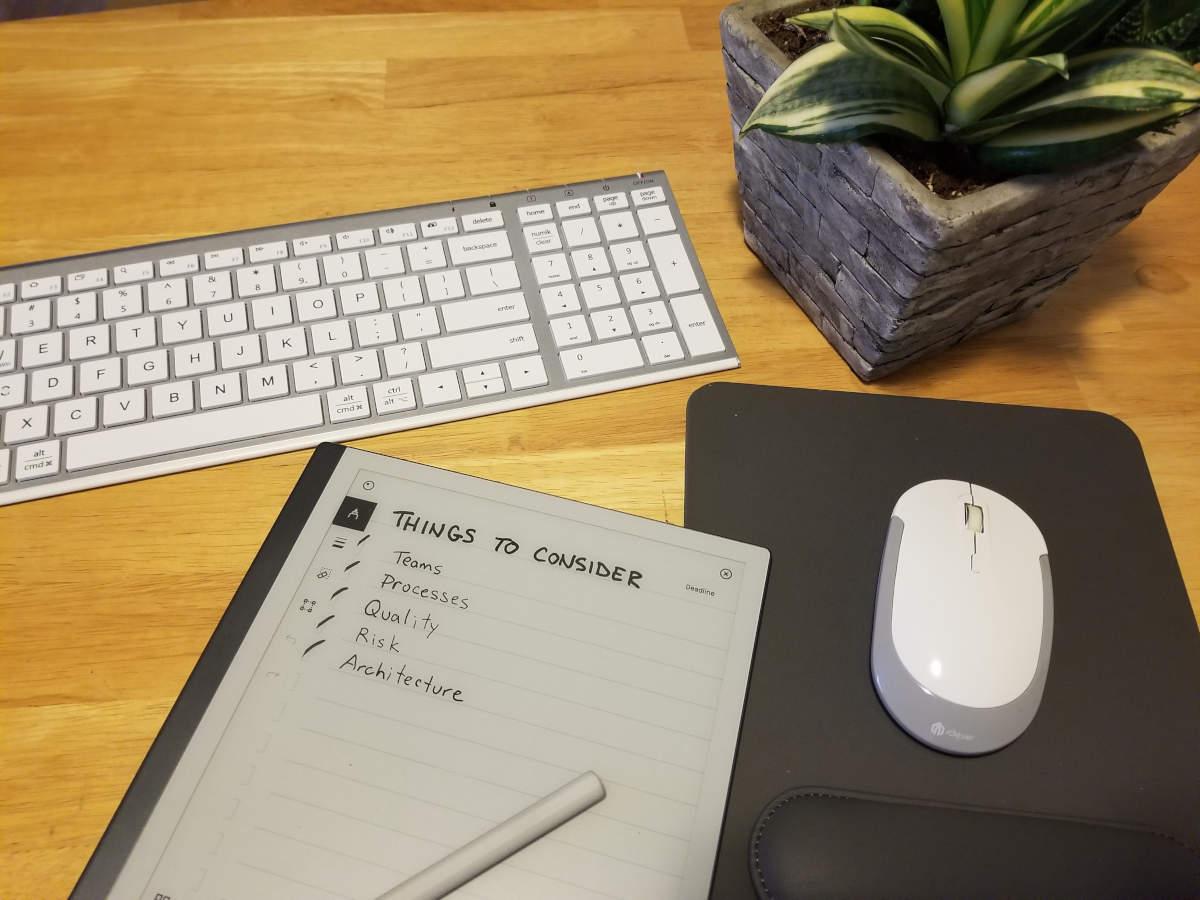 A desktop with a keyboard, mouse, plant and 'Things to Consider' check list.